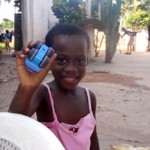 Smiling child holding a blue toy car