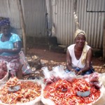 Women selling red chili peppers at market